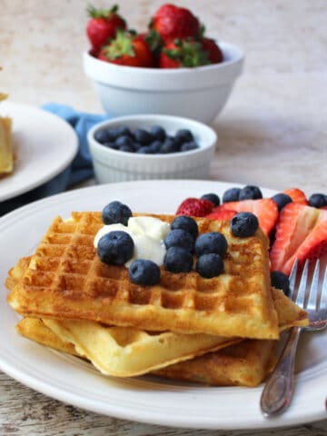 A white plate with homemade waffles and blueberries.
