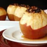 A white plate with a baked apple.