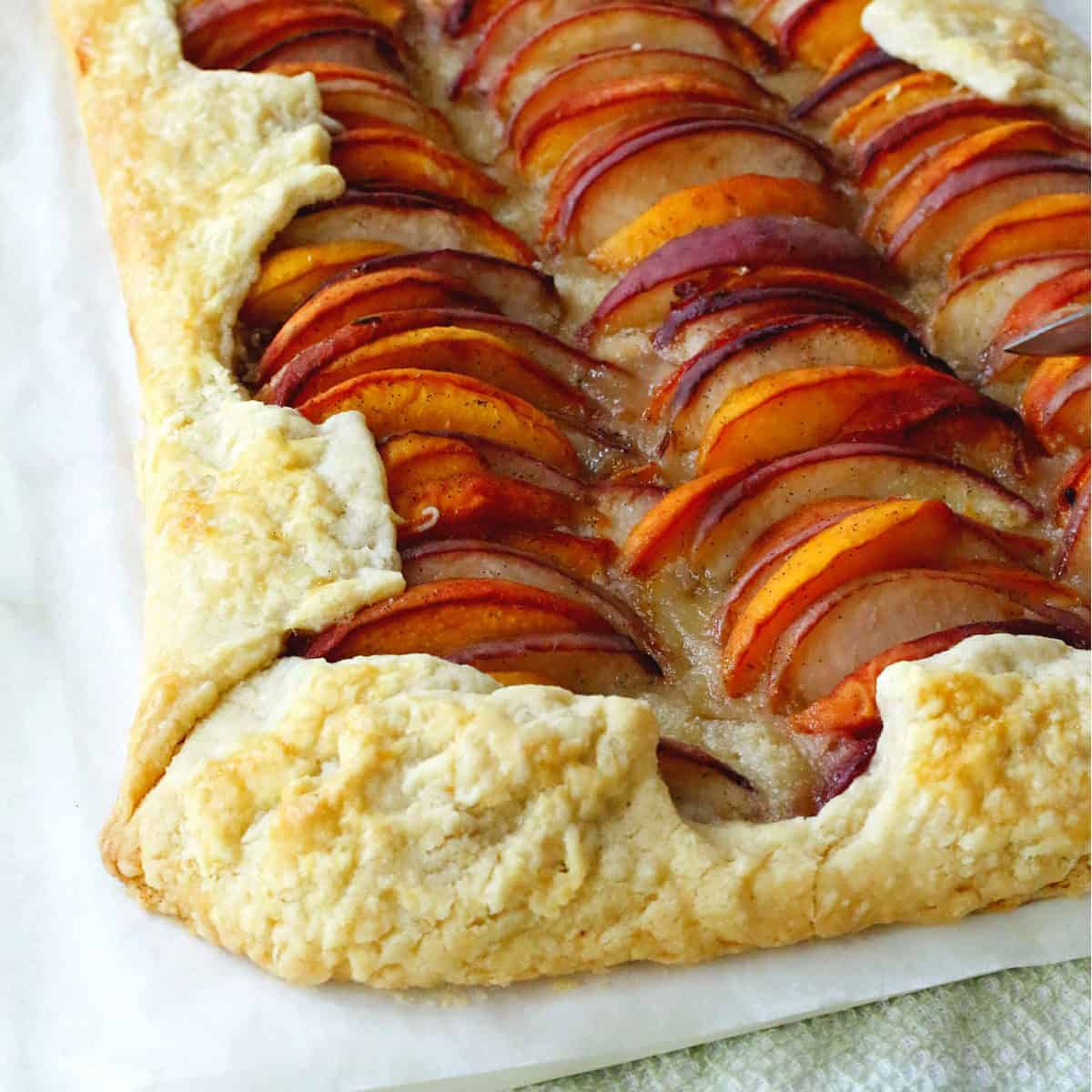 A peach tart with slices of peaches lining the tart.