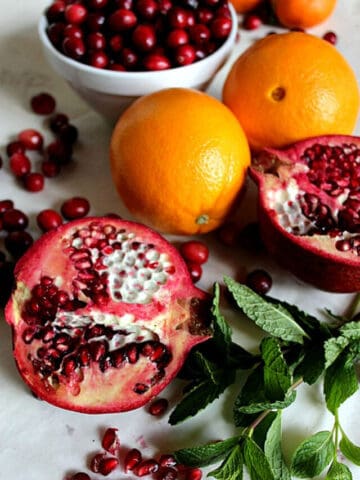 Oranges, cranberries and pomegranates with mint sprigs.