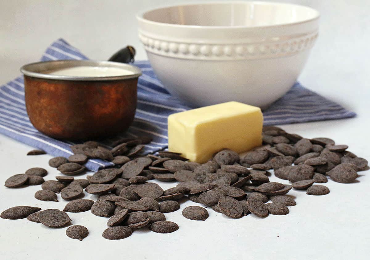 Chocolate wafers, butter, cream and a white bowl.