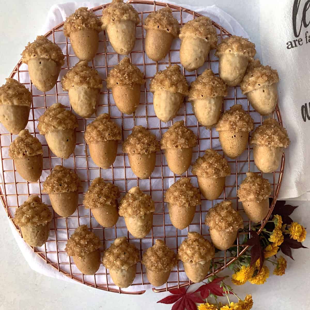 Maple cakes that look like acorns on a wire rack.