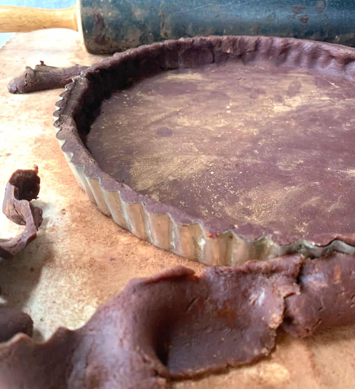Trimming the dough from a chocolate tart.