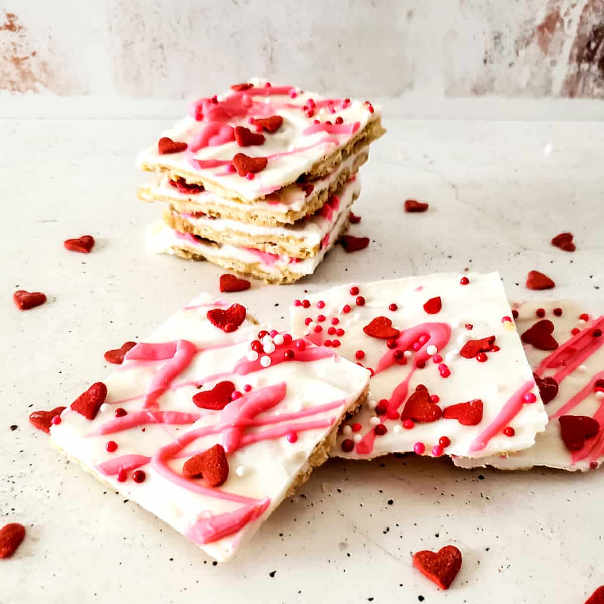 Cracker candy with white chocolate and red sprinkles.