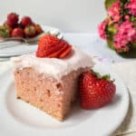 A slice of strawberry cake on a white plate.