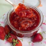 Strawberry jam with a spoon in the jar.