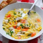 Chicken vegetable soup in a white bowl.