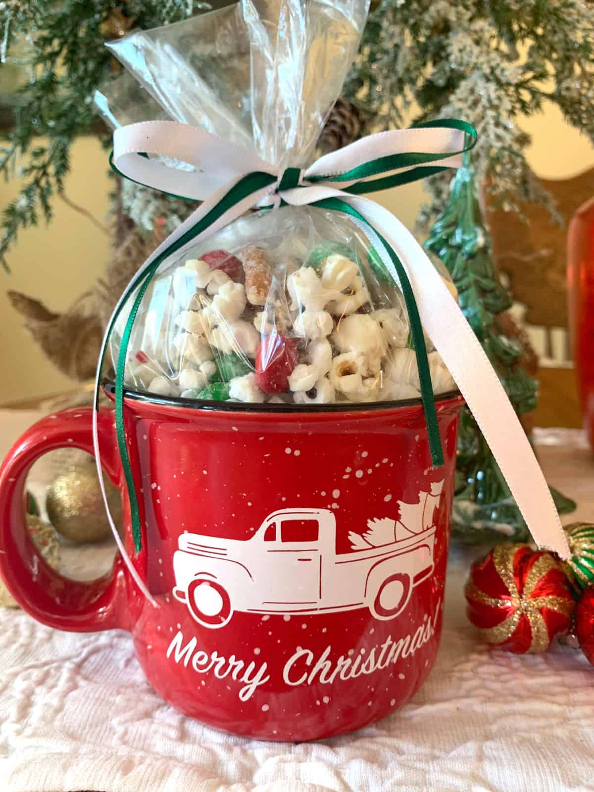 A red Christmas mug filled with popcorn crunch.