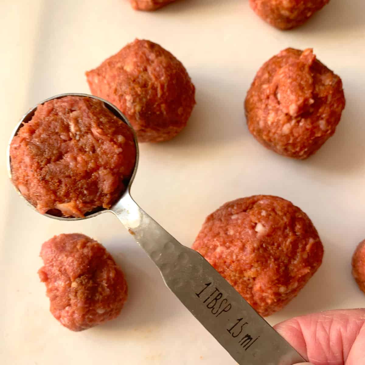 Making meatballs with a tablespoon.