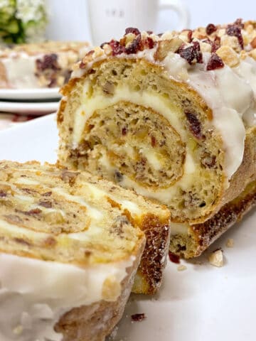A slice banana cake roll with icing on top.