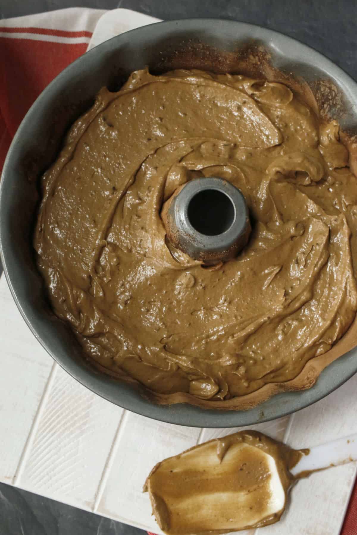Chocolate cake batter in a silver bundt pan.