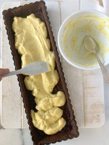 Spreading pastry cream in a chocolate tart.
