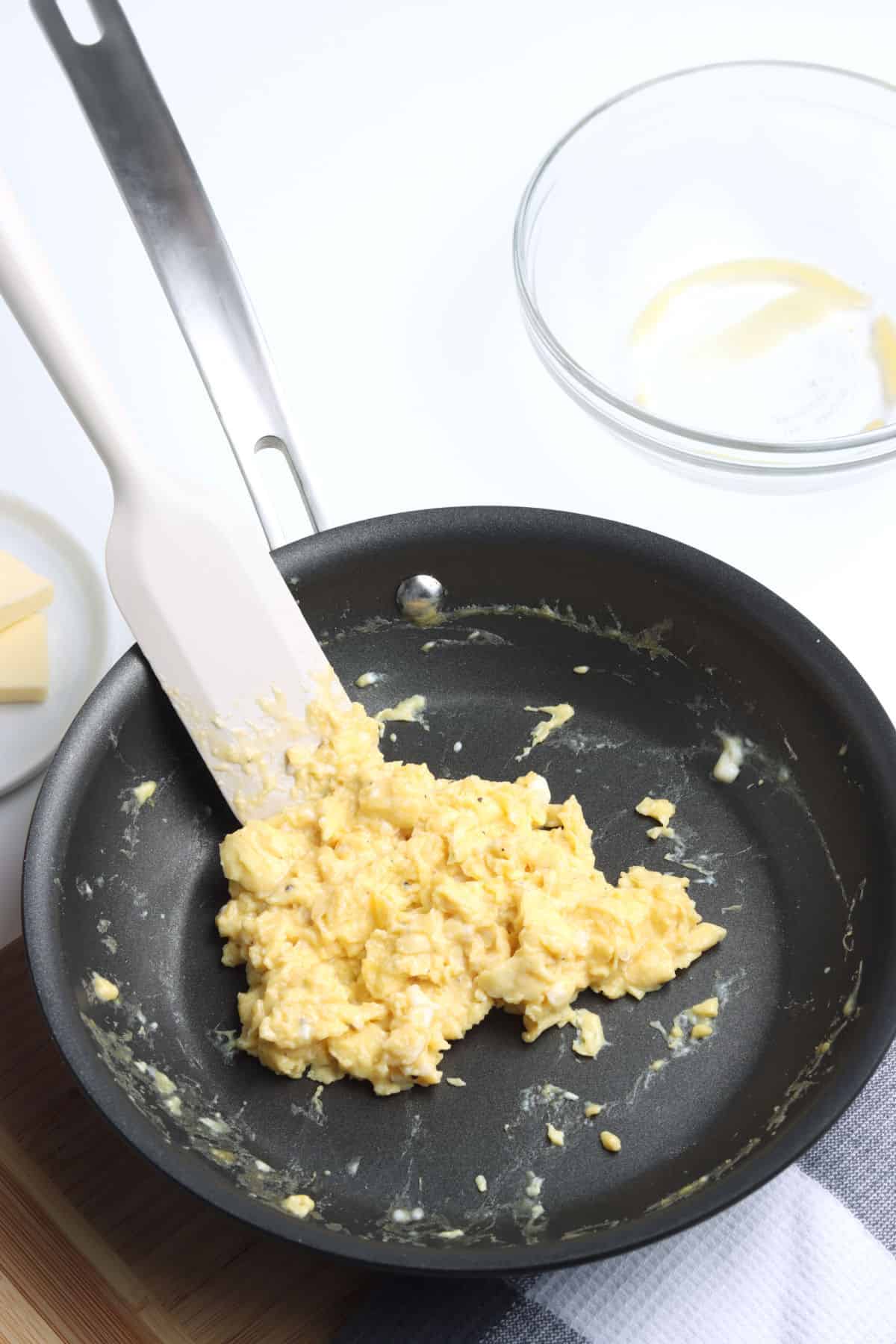 Cooked scrambled eggs in a pan.
