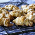 Cottage cheese butterhorn rolls on a wire rack on a blue towel.
