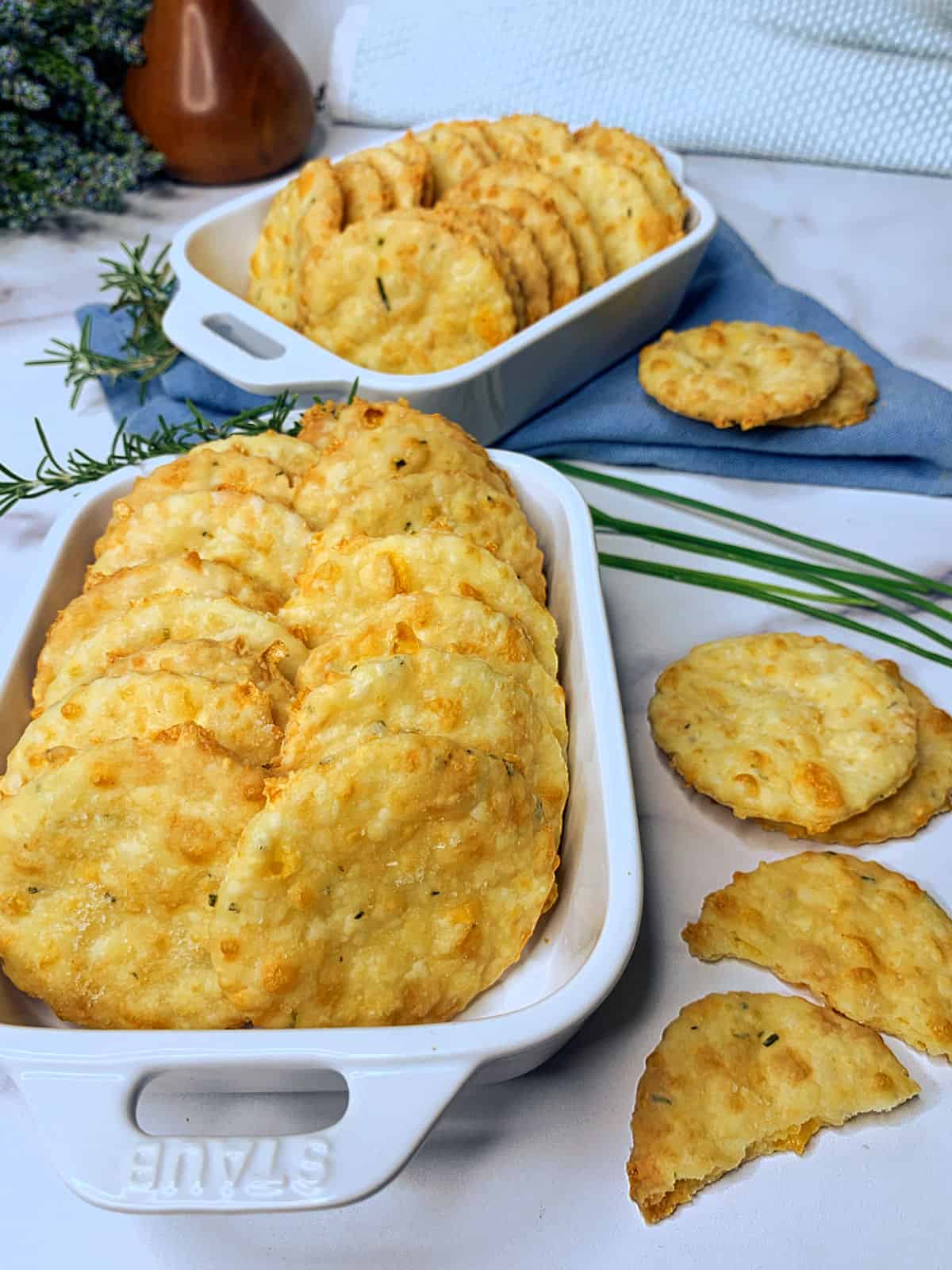 Cheddar cheese crackers in a white Staub casserole dish.