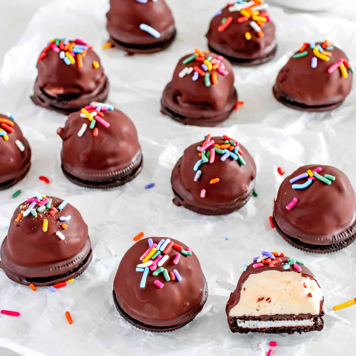 Chocolate dipped ice cream balls on a piece of paper.