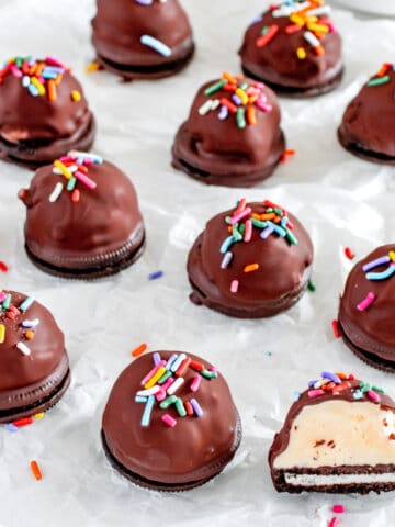 Chocolate dipped ice cream balls on a piece of paper.