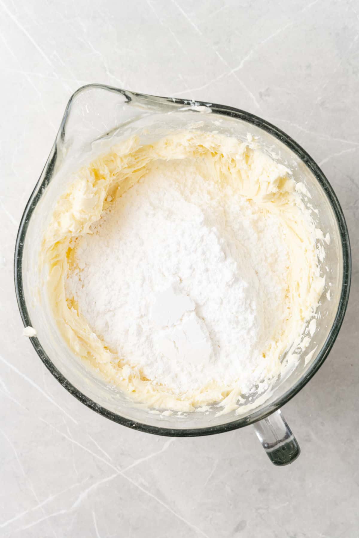 Adding powdered sugar to a white icing.