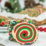 A stack of christmas cookies with icing and sprinkles.