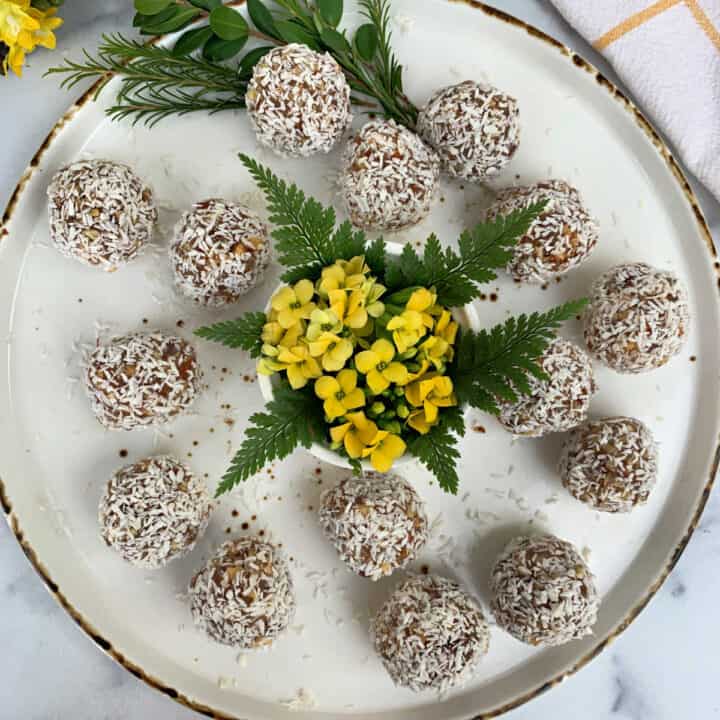 Coconut energy balls on a plate with yellow flowers.