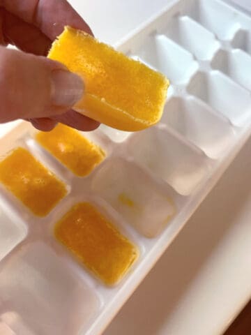 A person holding a frozen egg yolk.