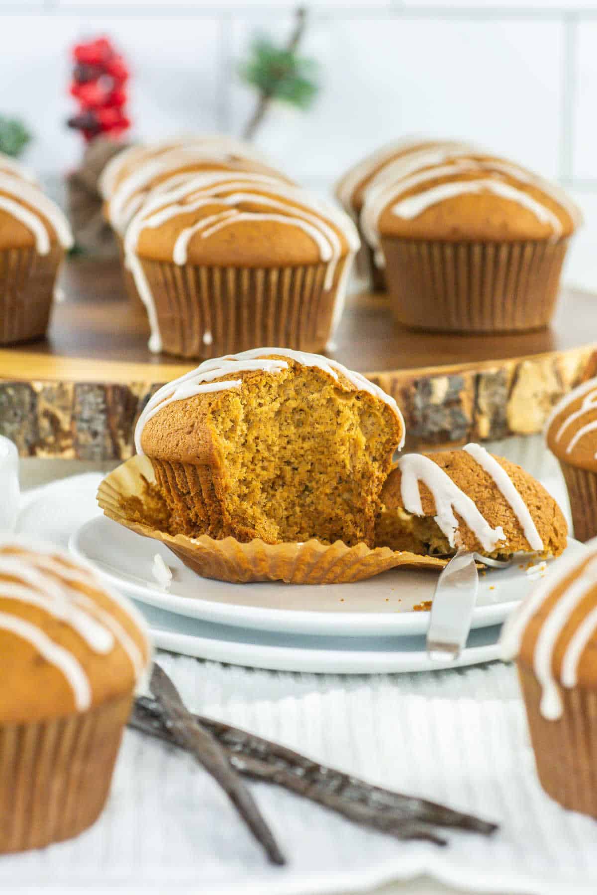 Gingerbread muffins with icing on a plate with a bite taken out.