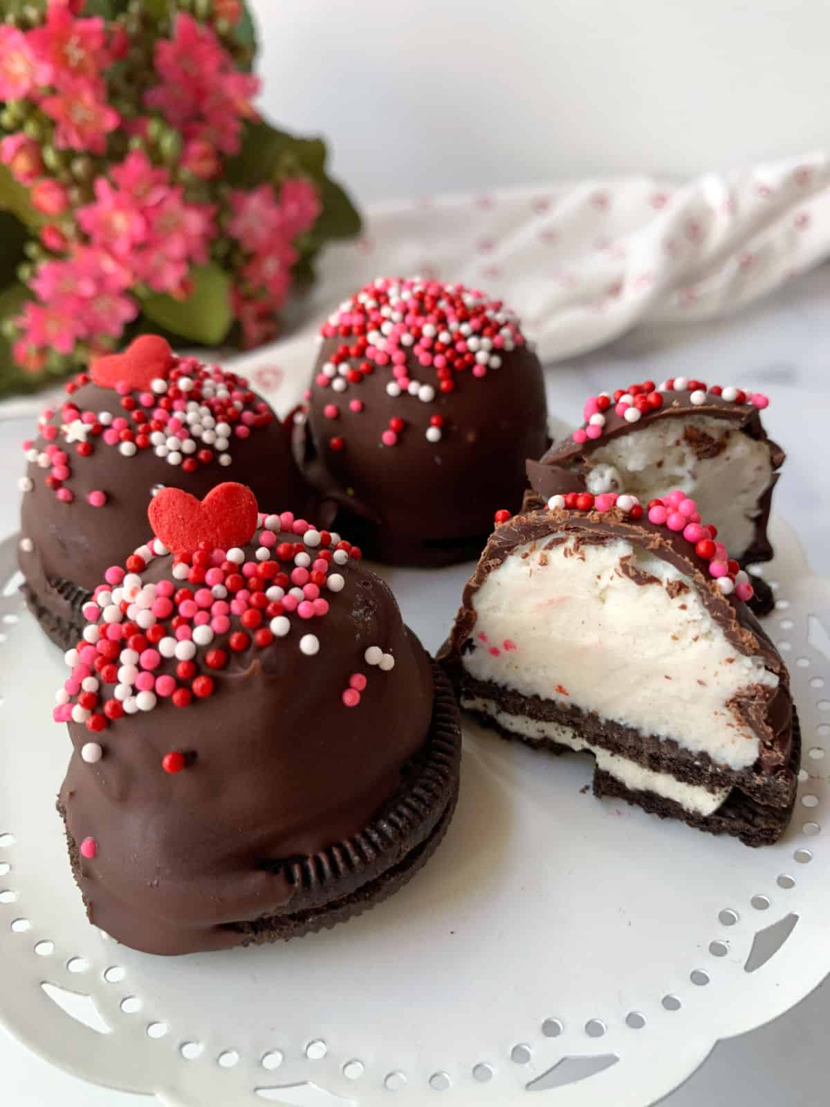 A plate of chocolate covered oreos with sprinkles.