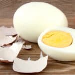 A peeled hard boiled egg wooden table.