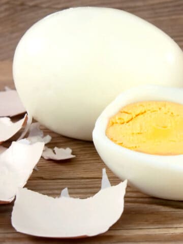 A peeled hard boiled egg wooden table.