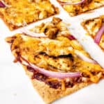 a baked Bbq chicken flatbread pizza with onions and cheese.
