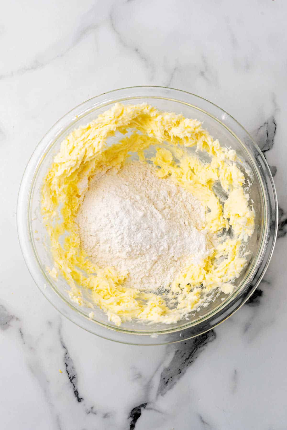 Flour in a bowl with creamed butter.