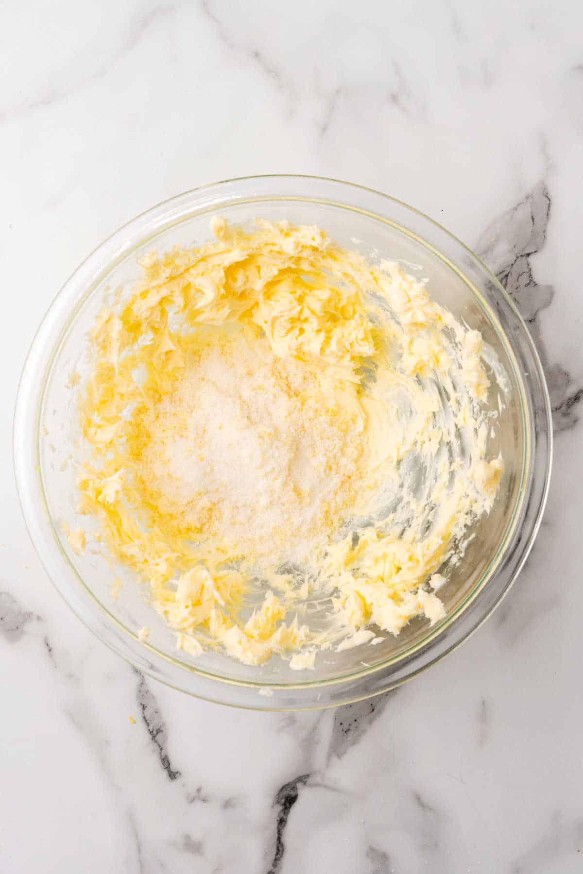 Creamed butter, and sugar in a glass bowl.
