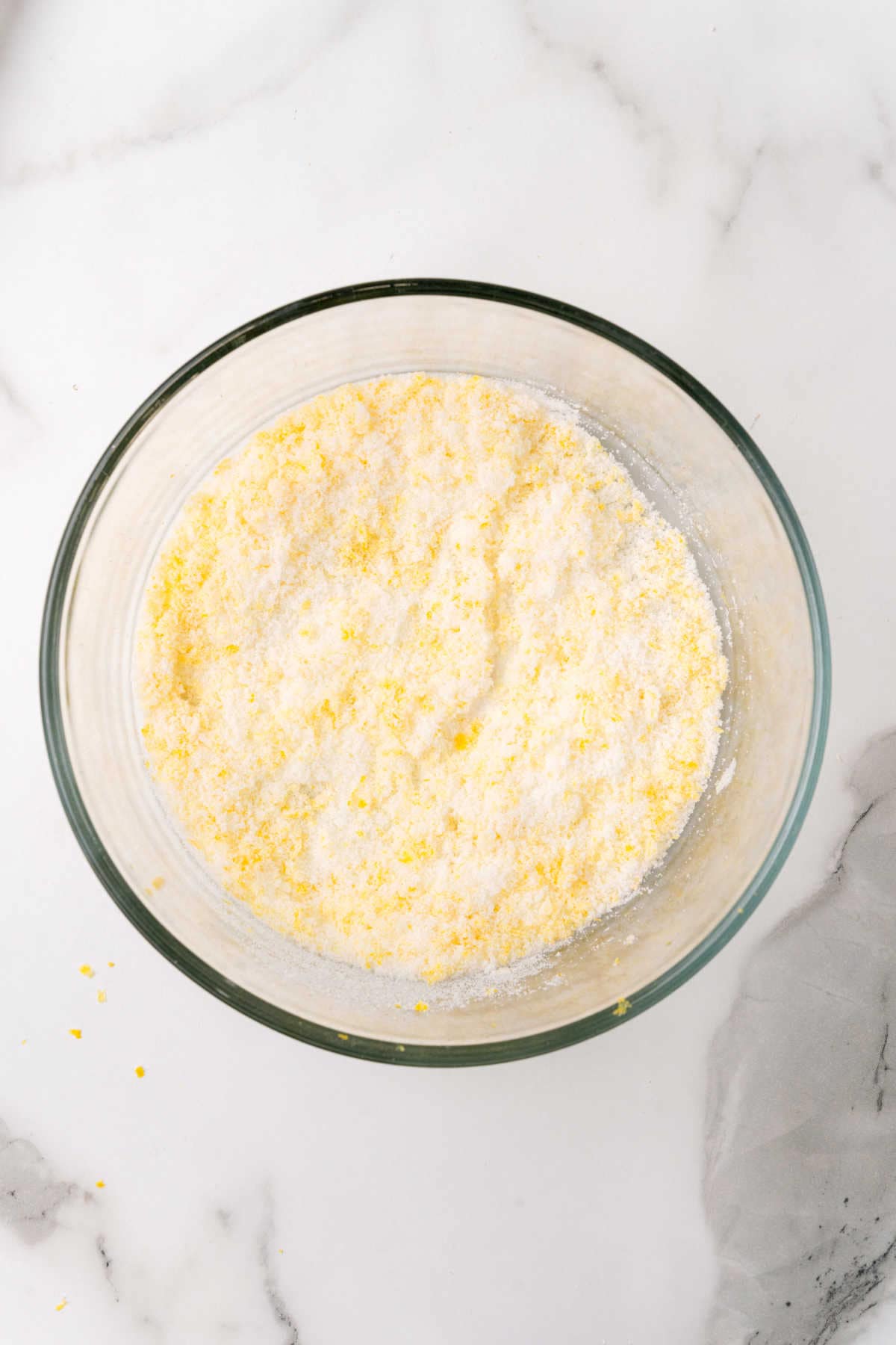 Mixed sugar and lemon zest in a glass bowl.