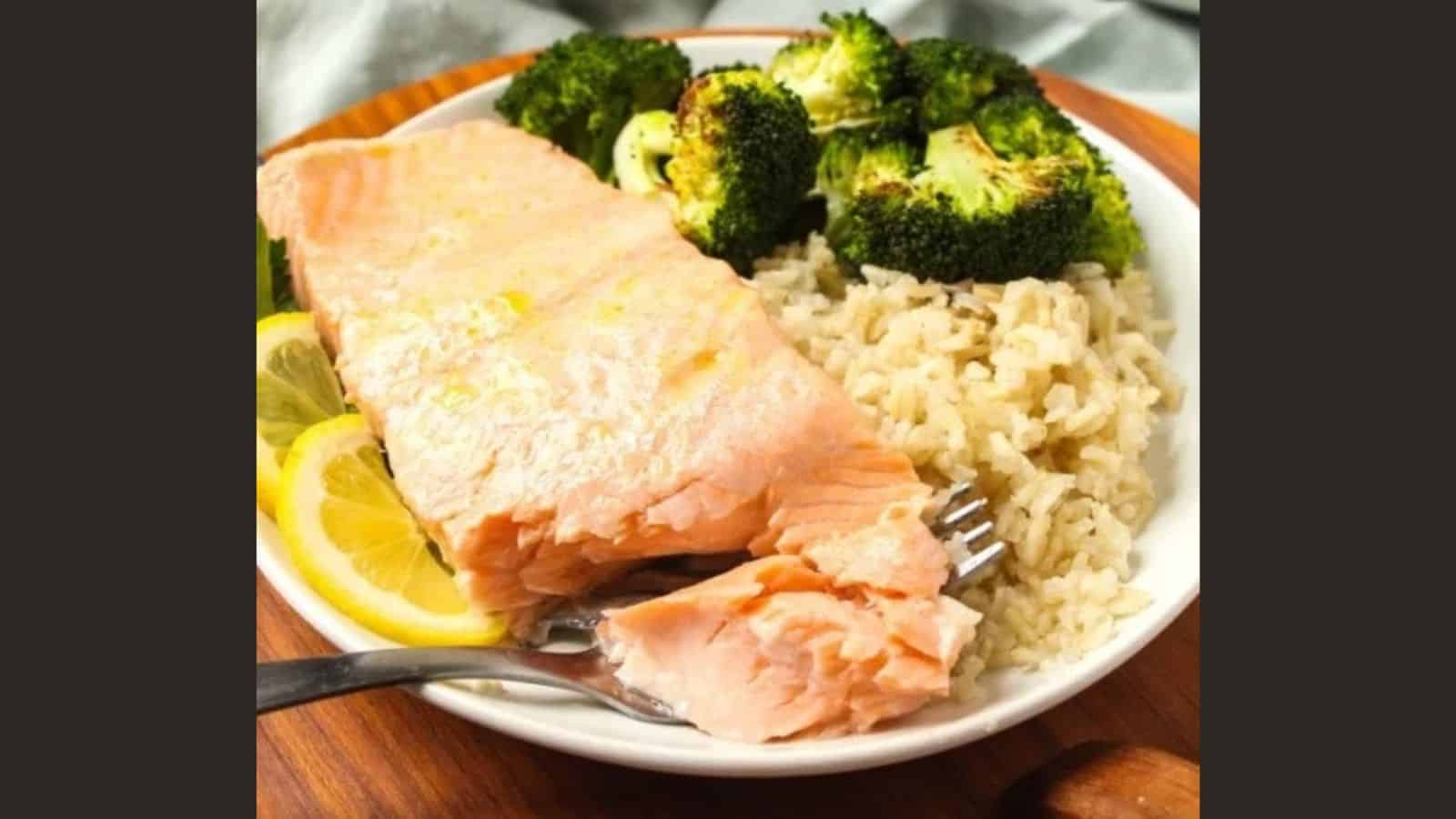 Baked salmon on a plate with rice and broccoli.