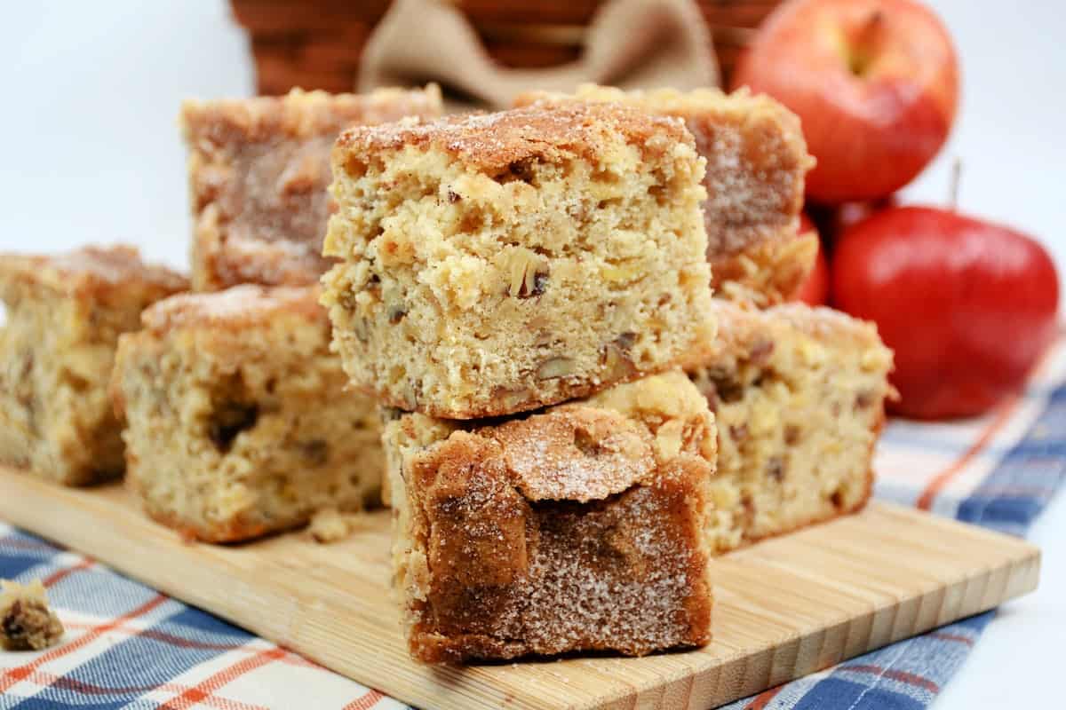 apple slices brown sugar cinnamon on a wooden board. Apples behind the brownies.