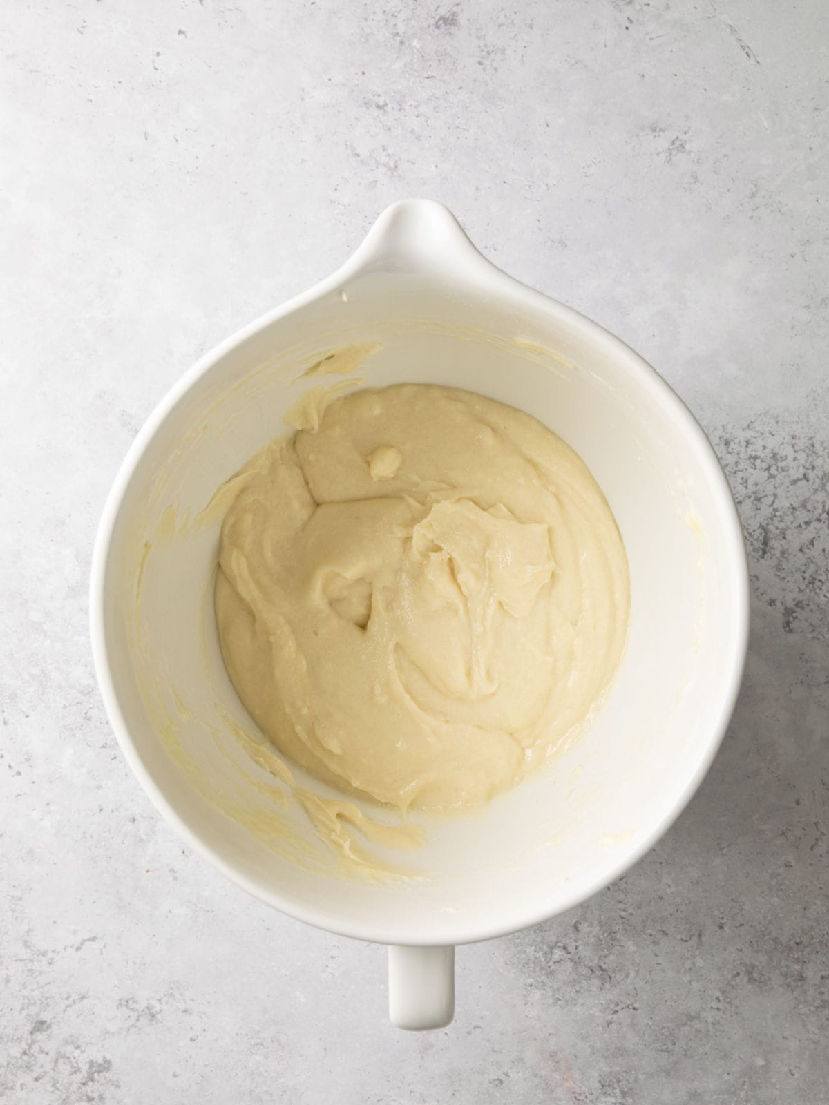 Batter in a white mixing bowl on a gray countertop.