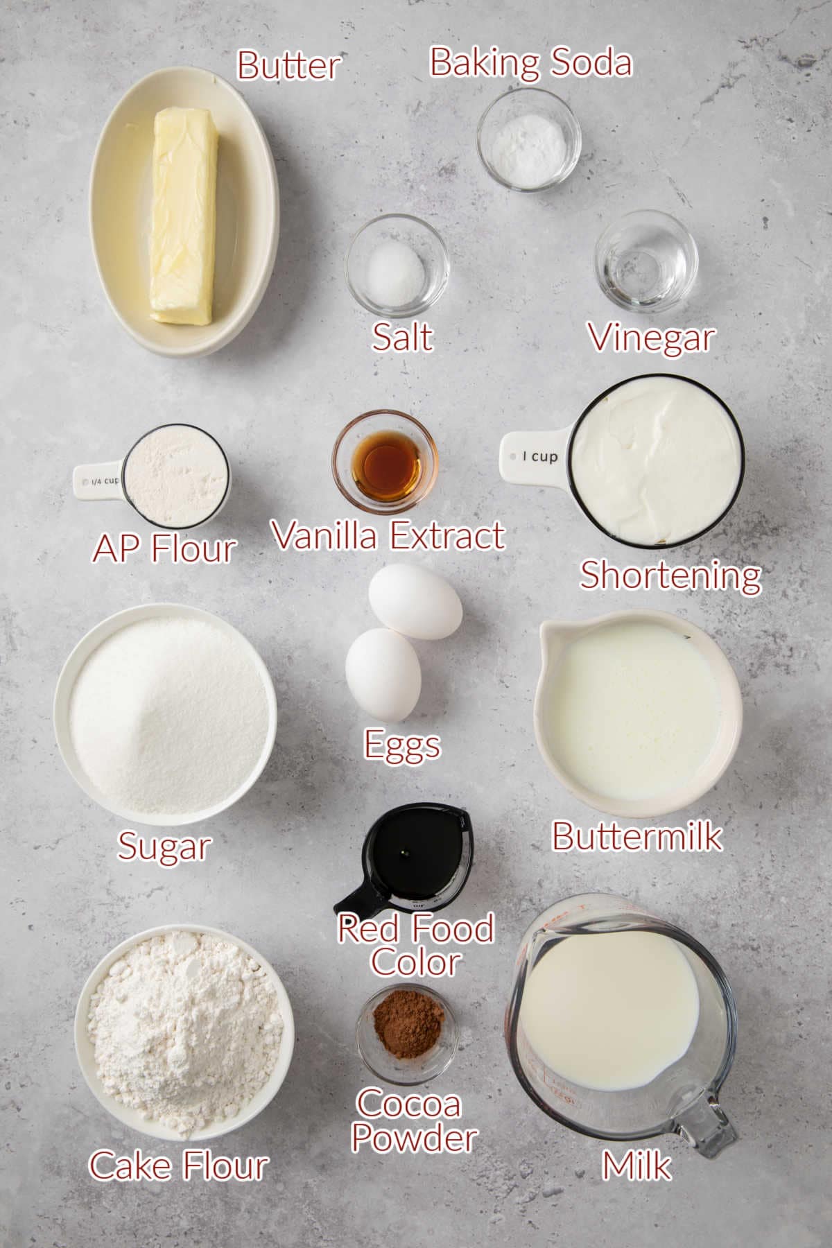 Various baking ingredients labeled, including butter, baking soda, salt, vinegar, all-purpose flour, vanilla extract, shortening, buttermilk, eggs, sugar, cake flour, cocoa powder, milk, and red food color.