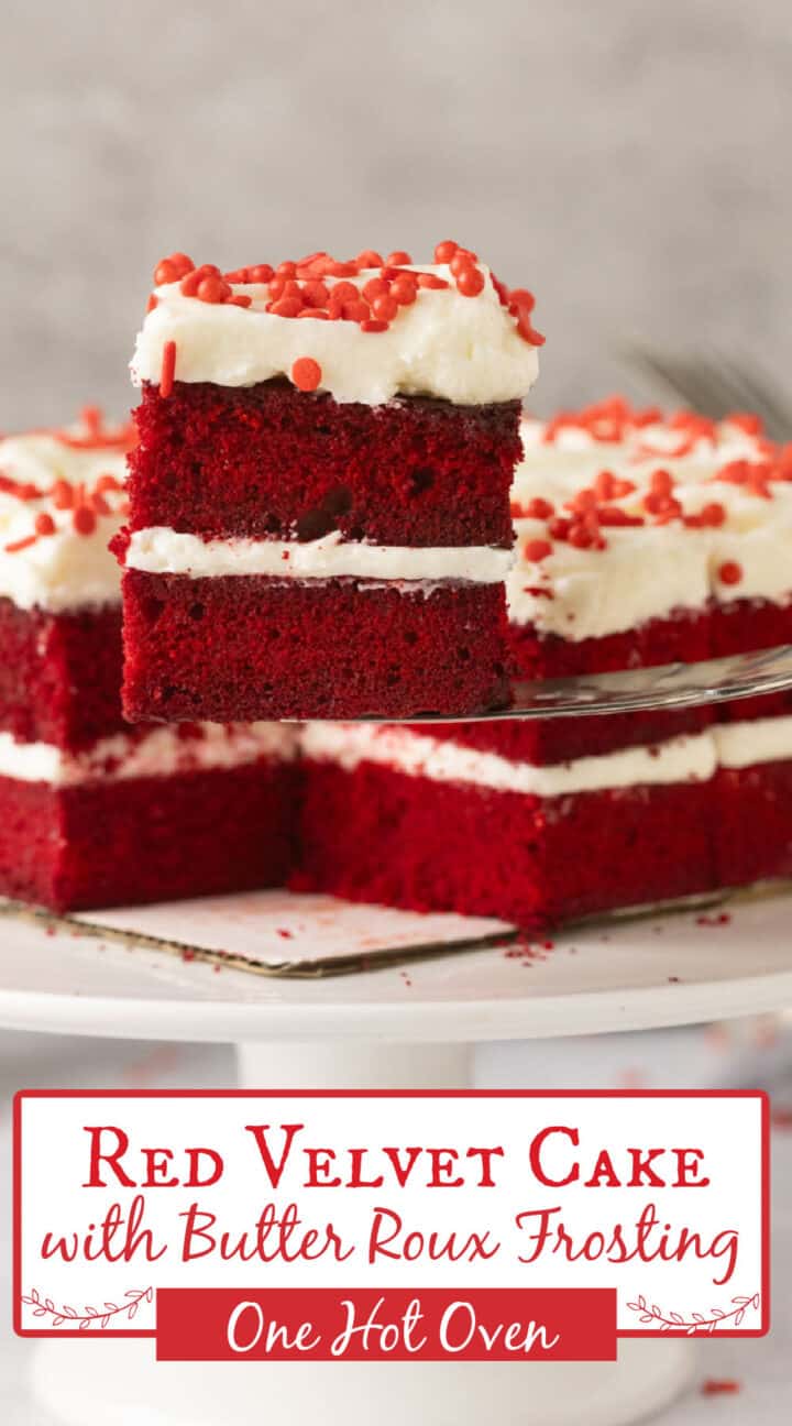 A slice of red velvet cake with white butter roux frosting and red sprinkles is displayed on a cake stand, with more slices in the background.