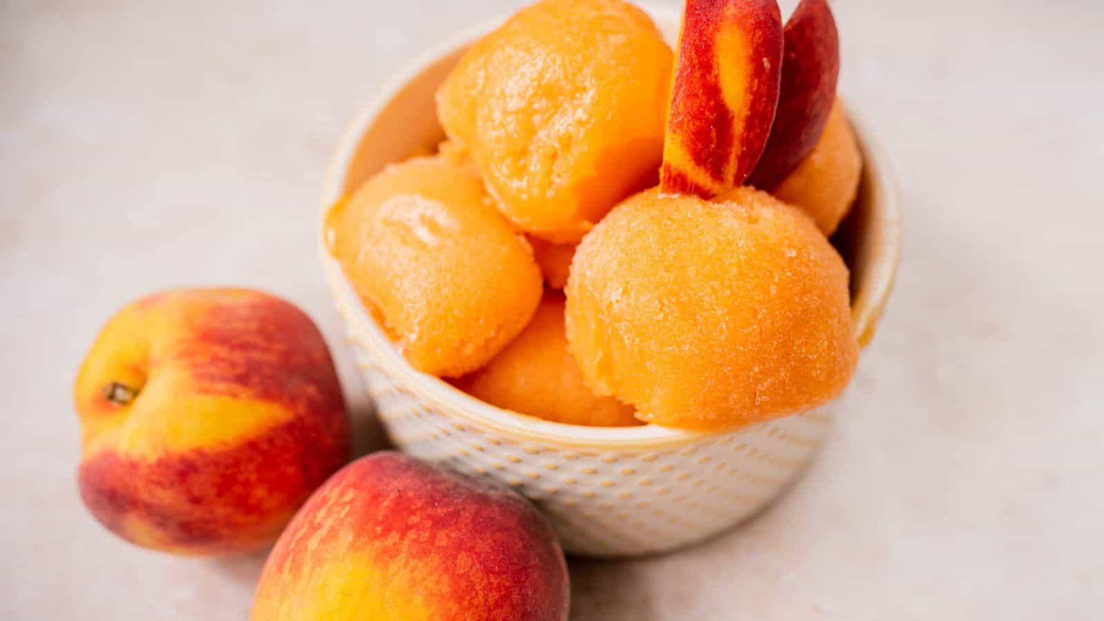 A small tan ceramic dish filled with mounds of fresh peach sorbet.