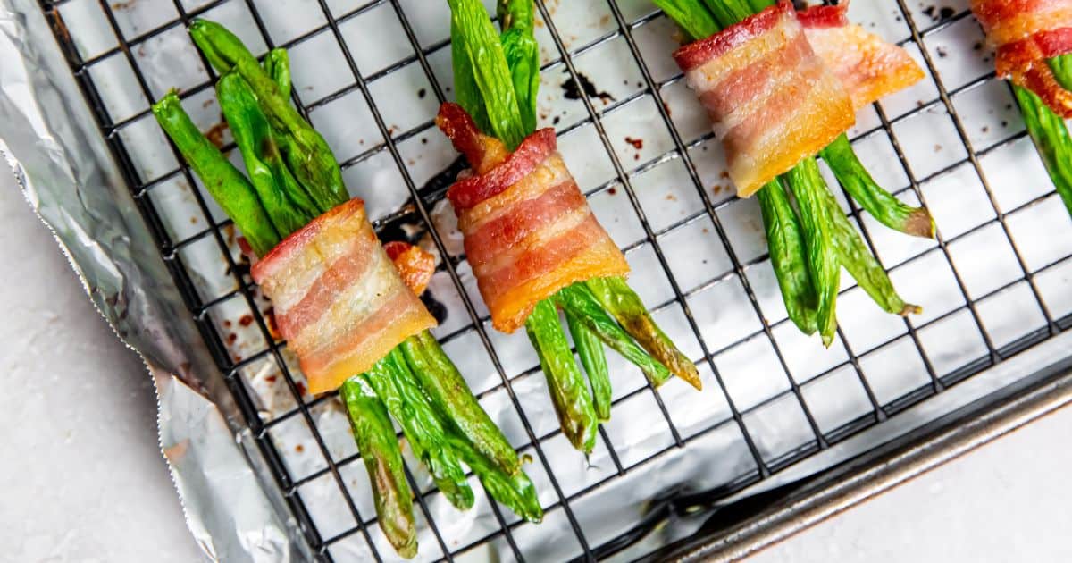 Bacon wrapped green beans on a cookie sheet