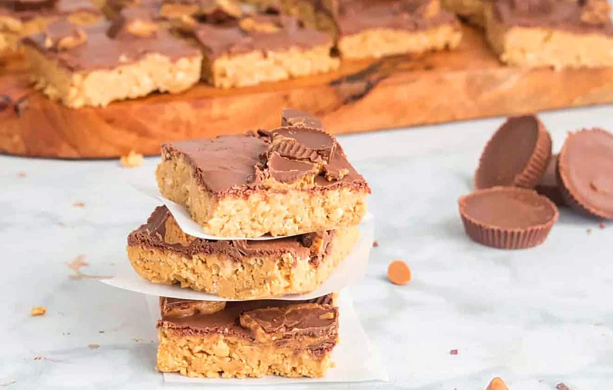 Stack of three crispy bars with the pan of dessert in the background.