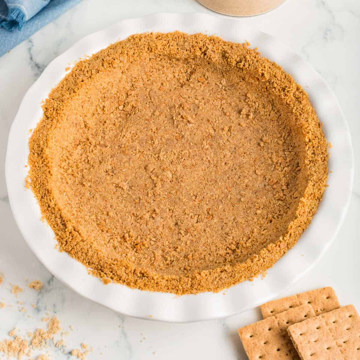 A white pie plate with a graham cracker pie crust.