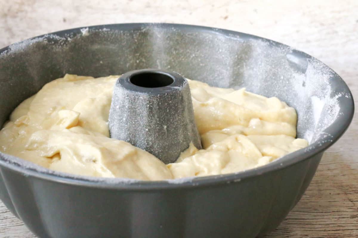 Unbaked cake batter in a floured bundt pan, ready to be placed in the oven.